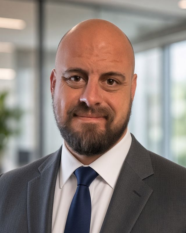 Michael Caito, native U.S. English coach, in a grey suit